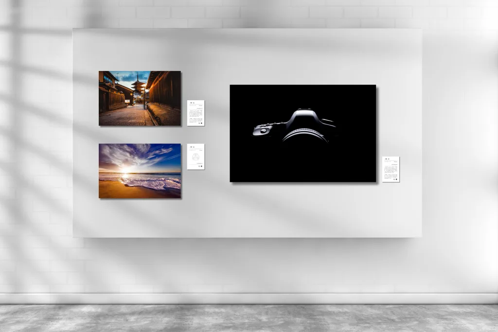展示イメージ図。白い壁に大小3点の写真パネルとキャプションが並ぶ